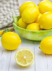 Fototapeta na wymiar Lemons in a green bowl on wooden background