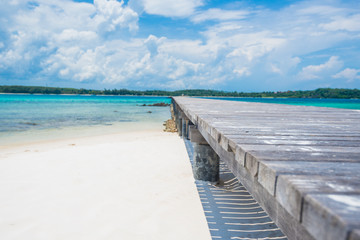 Long bridge on the white sand beach