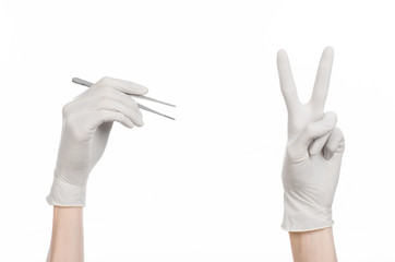 doctor's hand in a white glove holding tweezers isolated studio