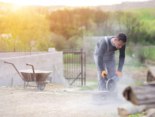 Bricklayer cutting a brick with circular saw