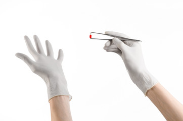 doctor's hand holding tweezers with red pill capsule isolated