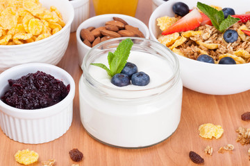 homemade yogurt with fresh berries and breakfast foods on table