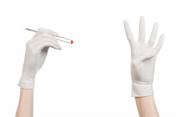 doctor's hand holding tweezers with red pill capsule isolated