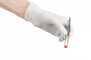 Fototapeta premium doctor's hand holding tweezers with red pill capsule isolated