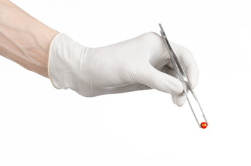 doctor's hand holding tweezers with red pill capsule isolated - 83543173