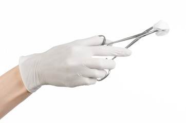 doctor's hand in white glove holding a surgical clamp with swab