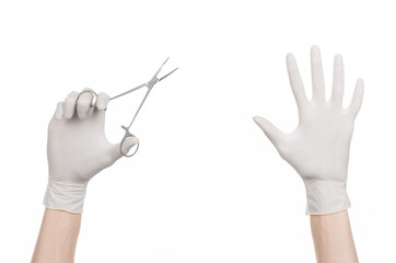 doctor's hand in white glove holding a surgical clamp with swab