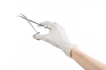 doctor's hand in a white glove holding a surgical clip isolated