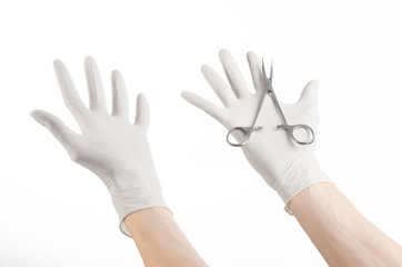 doctor's hand in white glove holding a surgical clamp with swab