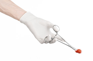 doctor's hand holding a surgical clip with a bloody tampon