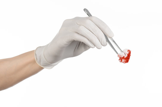 doctor's hand holding a surgical clip with a bloody tampon