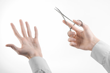 doctor's hand holding a surgical clamp scissors in studio