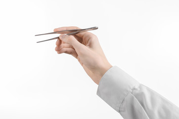 a doctor's hand holding tweezers isolated on white background