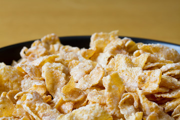 Black bowl with frosted cereal flakes