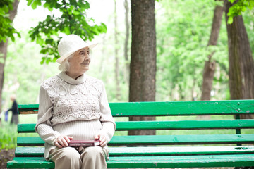 portrait of  happy grandmother on a park bench, 