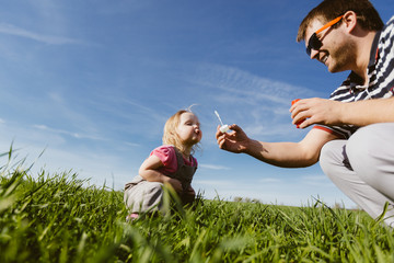 Dad and daughter blow bubbles