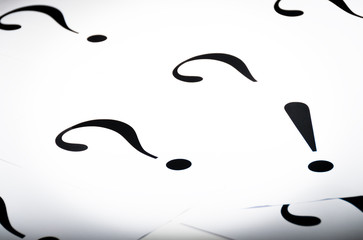 Printed question marks on the white paper 