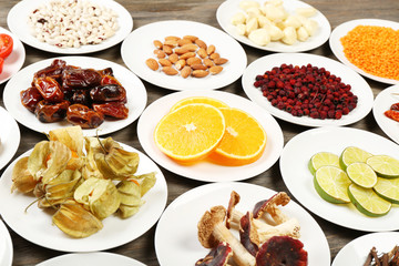 Different products on saucers on wooden table, closeup