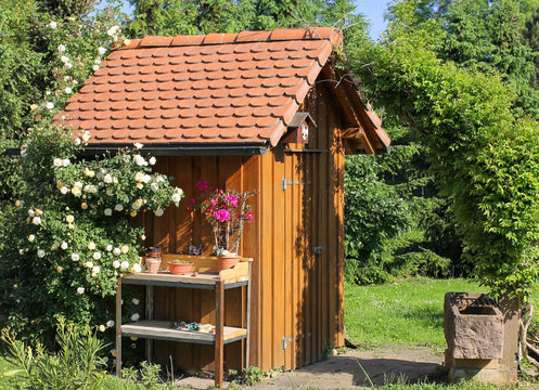 Gartenhaus mit Pflanztisch und Brunnentrog