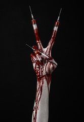 Bloody hand with syringe on the fingers, toes syringes in studio