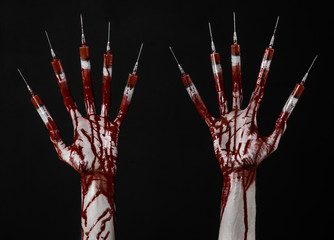 Bloody hand with syringe on the fingers, toes syringes in studio
