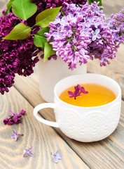 Cup of tea and lilac flowers