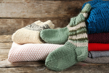 Knitting clothes on wooden background