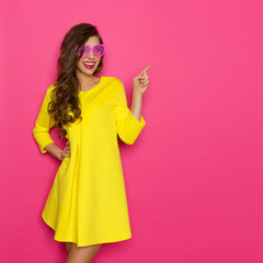 Cheerful Girl In Pink Sunglasses Pointing
