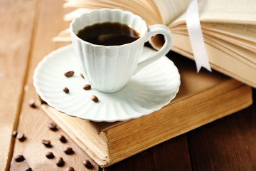 Still life with cup of coffee and books, on wooden table