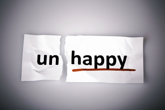 The word unhappy changed to happy on torn paper