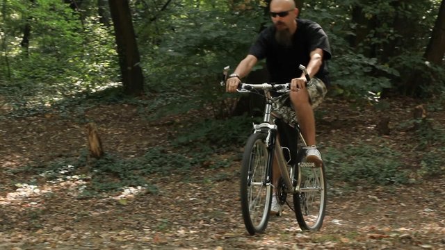 Mid adult man riding mountain bicycle in forest
