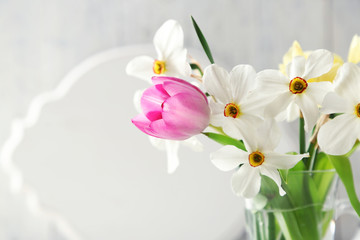 Fototapeta na wymiar Spring bouquet in glass mug on color wooden background