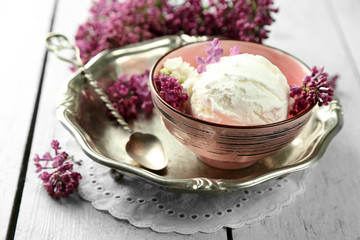 Beautiful composition with tasty ice cream and lilac flowers