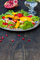 Salad with smoked salmon and edible flower on black 
