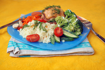 A plate of chicken with rice and vegetables
