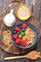 Muesli granola with honey, milk and berries . top view