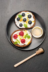 Bruschetta with goat cheese, berries and honey. top view