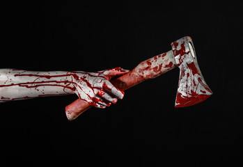 Obraz na płótnie Canvas bloody hand holding a bloody butcher's ax isolated in studio