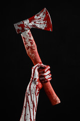 bloody hand holding a bloody butcher's ax isolated in studio