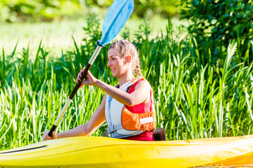 Frau fährt im Kajak auf Wald Fluss 