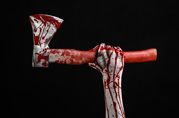 bloody hand holding a bloody butcher's ax isolated in studio - obrazy, fototapety, plakaty