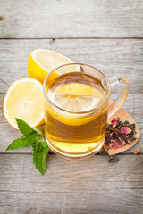 Green tea with lemon and mint on wooden table