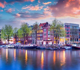 Zelfklevend Fotobehang Kleurrijke lentezonsondergang op de grachten van Amsterdam © Andrew Mayovskyy