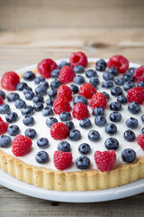Cake with blueberries and raspberries. Confectionery product.