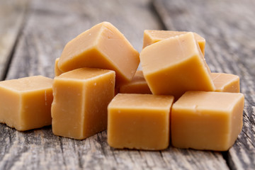 Tasty toffees on wooden background.