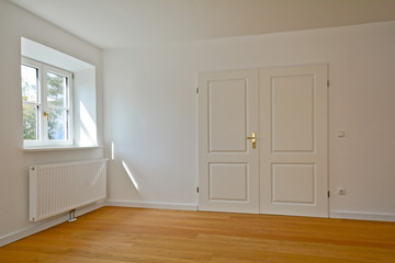 Fototapeta premium Wohnzimmer Altbau-Wohnung mit Parkett, Innentür und Holzfenster
