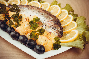 Grilled trout with olive, potato and vegetables