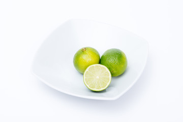tre lime in un piatto bianco