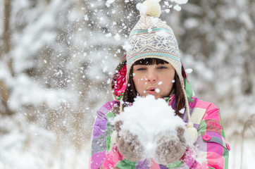 Girl blows snow from hands