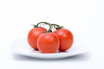 grappolo di pomodori rossi su piatto bianco